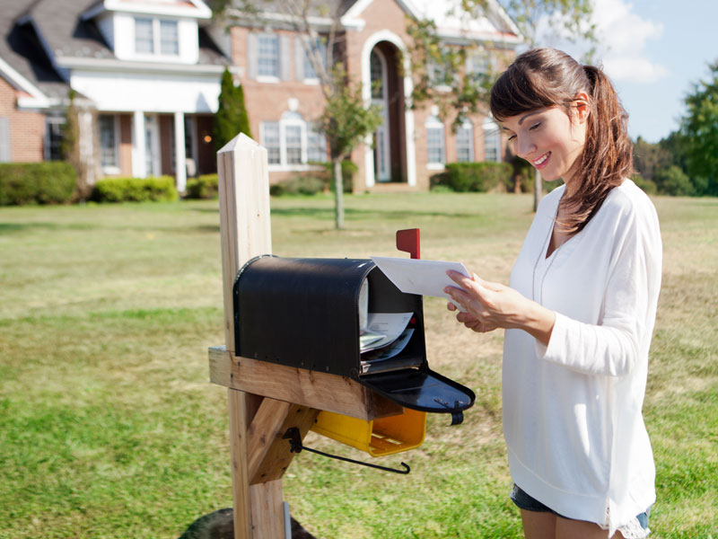 woman getting mail out of mailbox